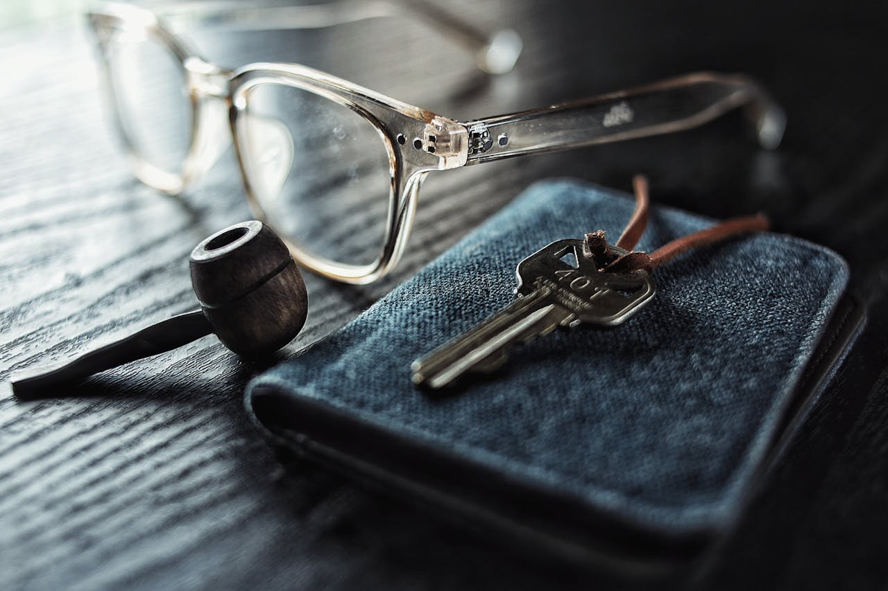 services-img A detailed image of glasses, a key, and a pipe on a textured wooden table.
